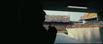 Dark Knight Rises Trailer Analysis: Tom Hardy lurking in the shadows of the stadium as Bane with a detonator